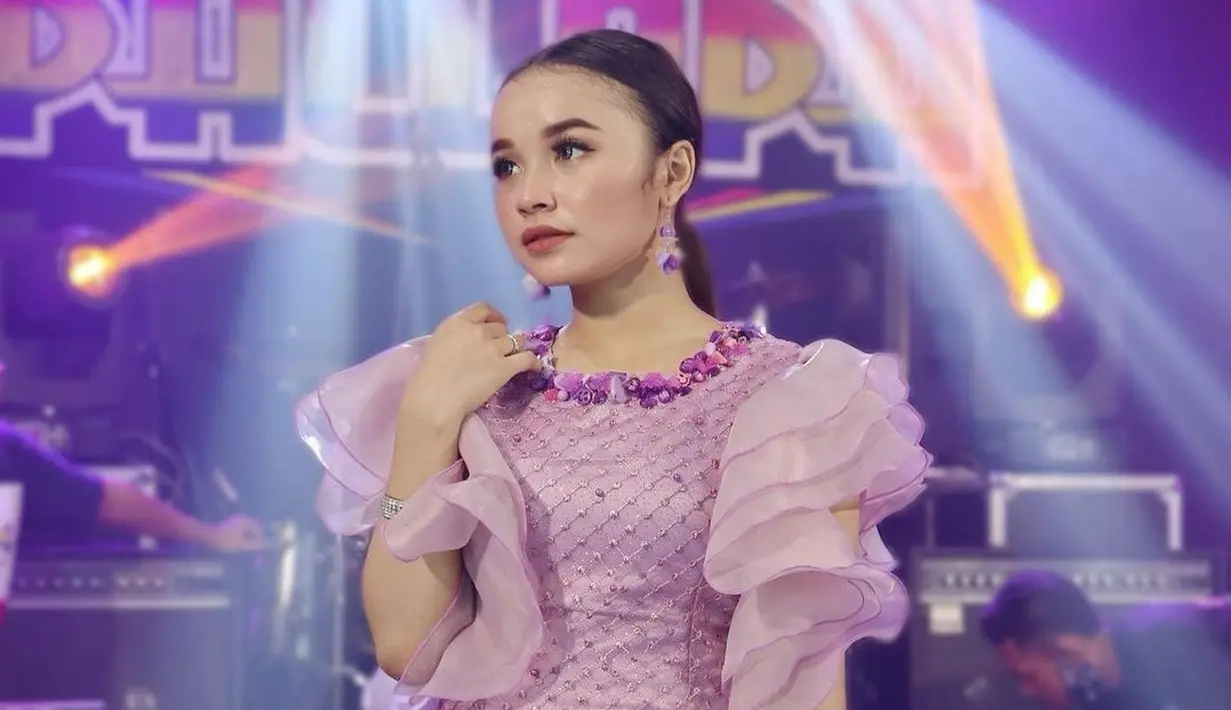 Sorotan lampu panggung membuat gadis berusia 18 tahun ini makin terlihat memesona dengan gaun ungunya. Penampilan Tasya memang selalu ditunggu-tunggu penggemar setianya. (Liputan6.com/IG/@tasya_ratu_gopo).