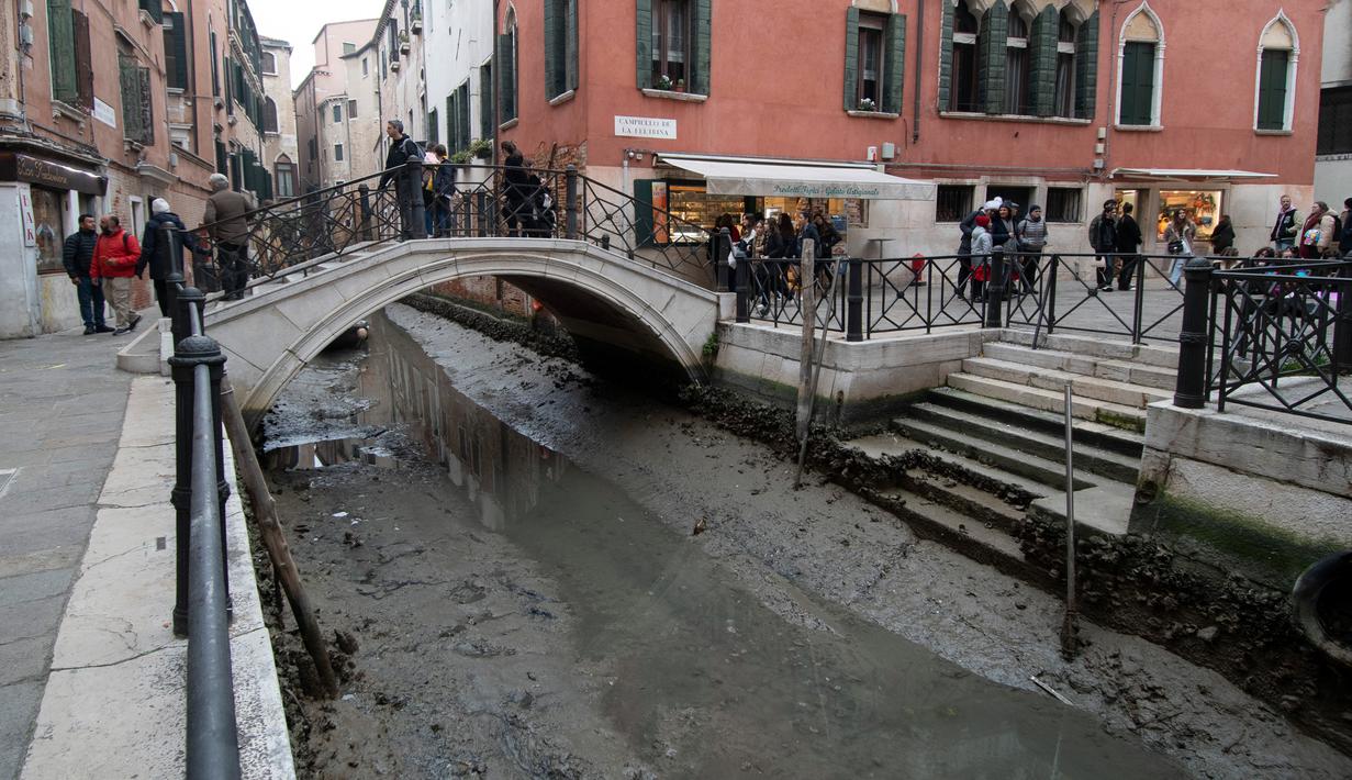 Pemandangan kanal kering saat air surut di Venesia, Italia, 21 Februari 2023. Italia menetapkan keadaan darurat kekeringan pada musim panas lalu. (AP Photo/Luigi Costantini)