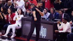 Rapper Drake berselebrasi saat menyaksikan pertandingan kelima Final NBA 2019 antara Golden State Warriors melawan Toronto Raptors di Scotiabank Arena, Toronto, Ontario (11/6/2019). Warriors memaksa Toronto Raptors memainkan gim keenam di NBA Final 2019. (Chris Young/The Canadian Press via AP)