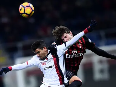 Gelandang AC Milan, Manuel Locatelli (kanan) berebut bola udara dengan penyerang Cagliari, Diego Farias pada lanjutan Liga Italia di Stadion San Siro (9/1). AC Milan menang tipis atas Cagliari dengan skor 1-0. (AFP Photo/Filippo Monteforte)