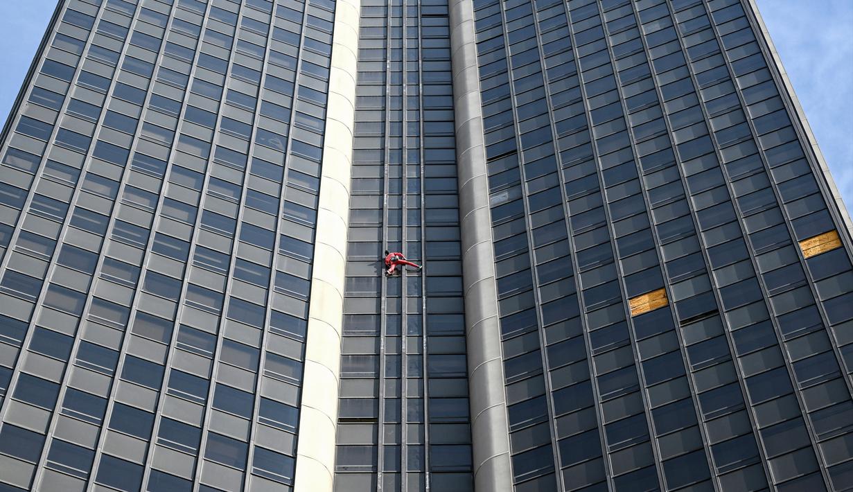 Alain Robert, pendaki bangunan pencakar langit asal Prancis memanjat Menara Montparnasse di Paris, Prancis, Rabu (12/10/2022). Alain Robert yang dikenal sebagai Spiderman Prancis itu kembali beraksi dengan memanjat Menara Montparnasse yang memiliki ketinggian 210 meter. (Bertrand GUAY/AFP)