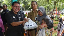 Sekretaris Perusahaan PT Asabri (Persero) Djoko Rachmadhy secara simbolis menyerahkan sembako murah di RPTRA Alur Dahlia, Tegal Alur, Jakarta Barat, Selasa (21/5/2019). PT Asabri (Persero) menjual sebanyak 3 ribu sembako seharga Rp 10 ribu kepada masyarakat sekitar. (Liputan6.com/Johan Tallo)