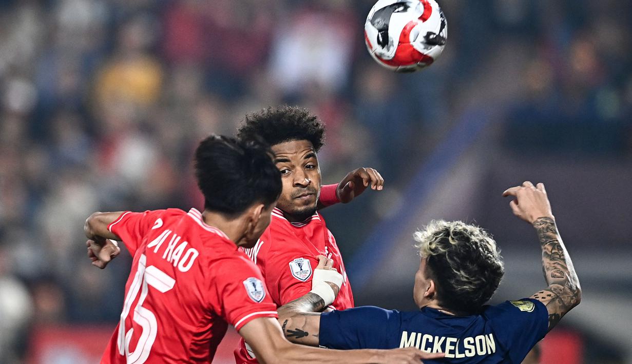 <p>Pemain naturalisasi baru Vietnam, Nguyen Xuan Son (tengah) berduel udara dengan pemain Thailand, Nicholas Mickelson dalam laga leg pertama final Piala AFF 2024 yang berlangsung di Viet Tri Stadium, Vietnam, Selasa (02/01/2025) waktu setempat. (AFP/Nhac Nguyen)</p>