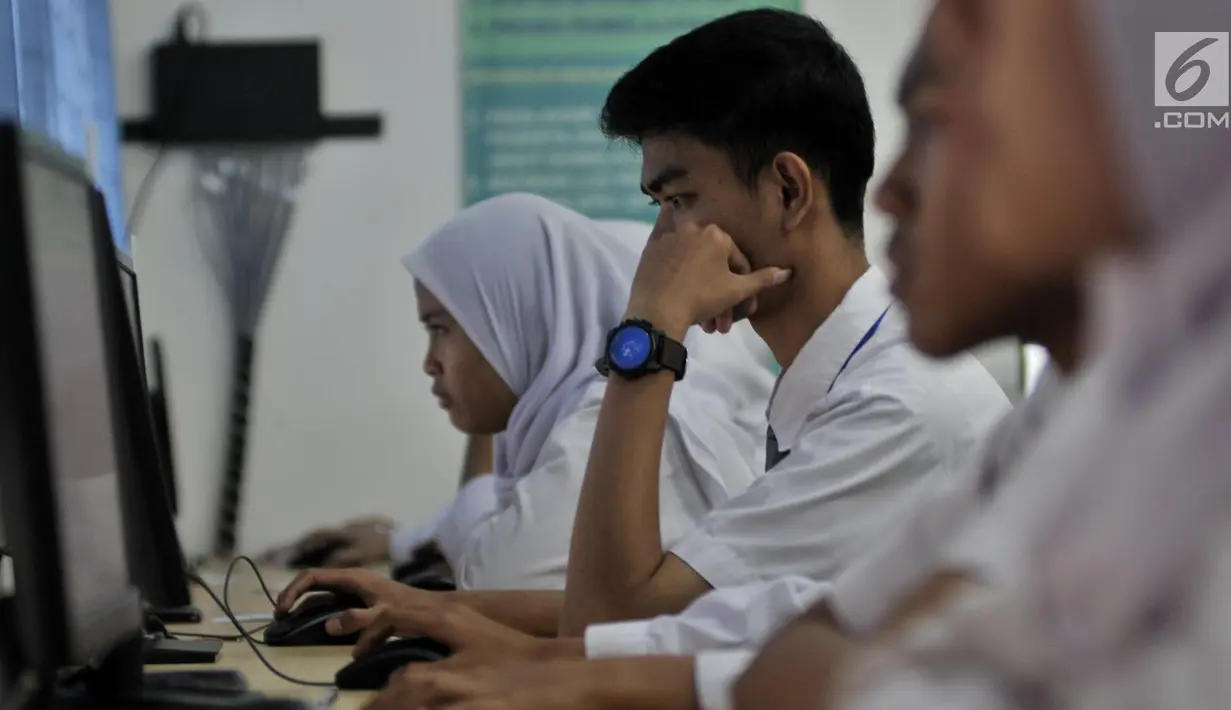 Sejumlah siswa kelas XII mengerjakan soal Bahasa Indonesia saat mengikuti Ujian Nasional Berbasis Komputer (UNBK) di SMKN 50 Jakarta, Senin (25/3). Kemendikbud mengatur UNBK tingkat SMK dilaksanakan serentak dalam empat hari mulai 25 sampai 28 Maret 2019. (merdeka.com/Iqbal S. Nugroho)