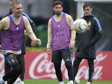 Penyerang Argentina, Lionel Messi (kanan) mengamati bola di samping gelandang Franco Mastantuono selama sesi latihan di Ezeiza, Provinsi Buenos Aires, Argentina, pada 2 September 2025. (JUAN MABROMATA/AFP)