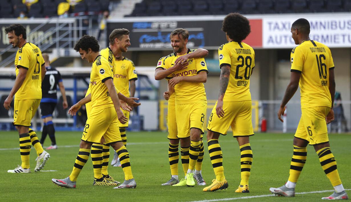 Para pemain Borussia Dortmund merayakan gol yang dicetak oleh Marcel Schmelzer ke gawang SC Paderborn 07 pada laga Bundesliga di Stadion Benteler, Minggu (31/5/2020). Borussia Dortmund menang dengan skor 6-1 SC Paderborn 07. (AP/Lars Baron)