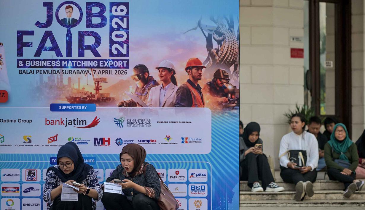 Para pencari kerja mendaftar melalui ponsel mereka di salah satu event bursa kerja, Surabaya, Jawa Timur pada Selasa 7 April 2026. Dinas Perindustrian dan Tenaga Kerja (Disperinaker) Kota Surabaya, Jawa Timur, menggelar Job Fair Surabaya Industrial & Labour (SIL) 2026. (JUNI KRISWANTO/AFP)