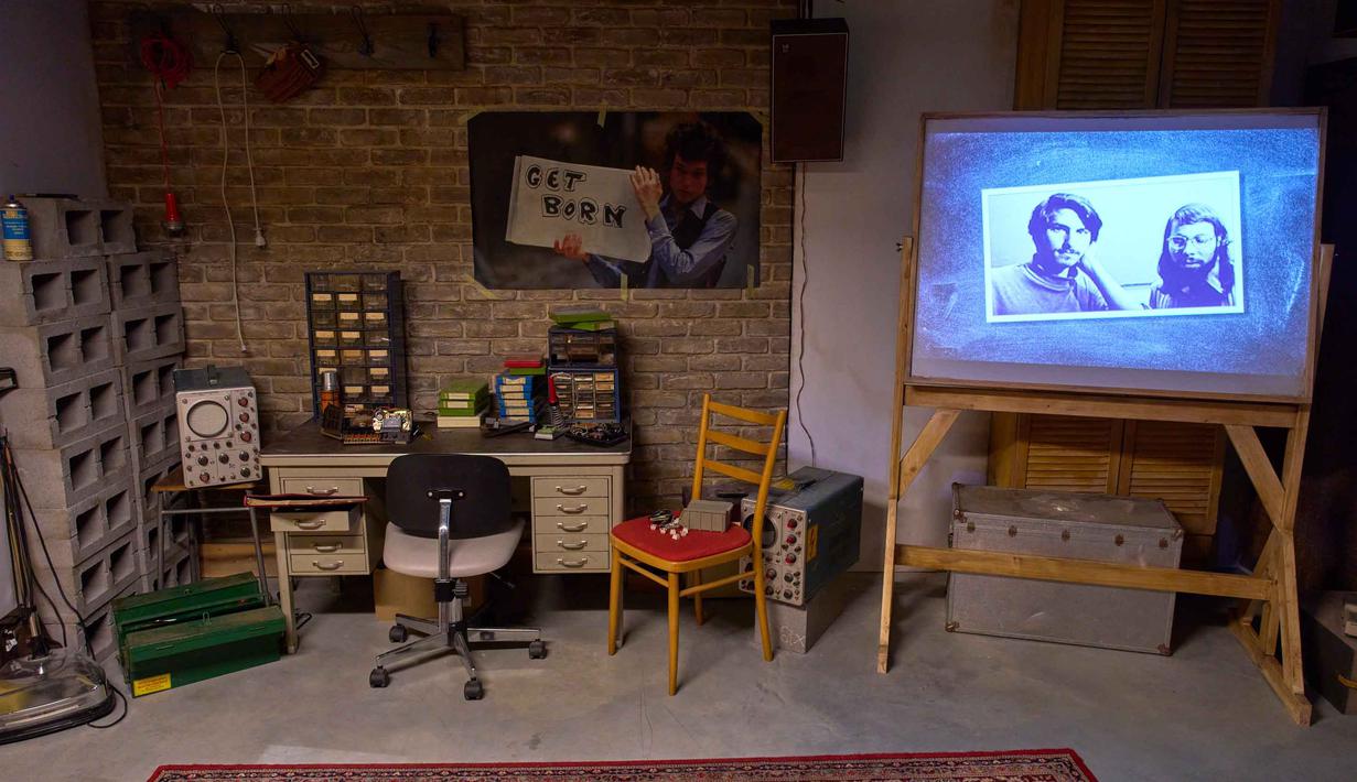 Inovasi tersebut kemudian berlanjut dengan hadirnya berbagai perangkat populer seperti iPod, iPhone, iPad, Apple Watch, serta lini komputer Mac. Tampak foto pendiri Apple, Steve Wozniak (kanan) dan Steve Jobs, dipajang dalam dekorasi garasi tempat semuanya bermula, di Museum Apple baru yang menelusuri 50 tahun inovasi merek ikonik tersebut, di Utrecht, Belanda, Rabu, 1 April 2026. (AP Photo/Peter Dejong)