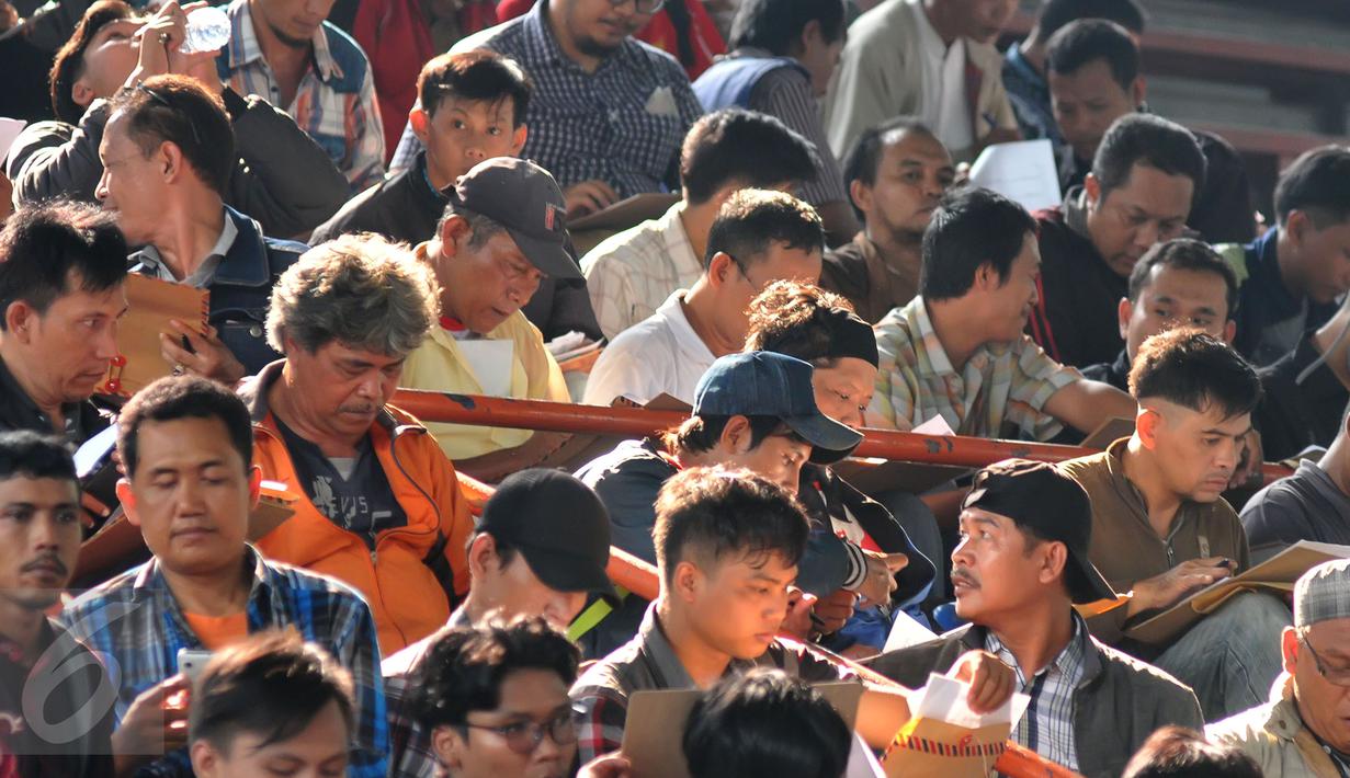 Para pendaftar pengendara Go-Jek saat serius mengisi formulir pendaftaran di Hall A Basket Senayan, Jakarta, Jumat (14/8/15). Fenomena ojek online dengan aplikasi di hanphone kini banyak diminati. (Liputan6.com/Herman Zakharia)
