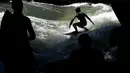 Seorang pria berusaha menaklukkan ombak buatan saat bermain surfing di sungai 'Eisbach' di taman English Garden di Munich, Jerman (24/6/2019). Eisbach merupakan sungai buatan dengan panjang dua kilometer dan arusnya pun merupakan buatan. (AP Photo/Matthias Schrader)