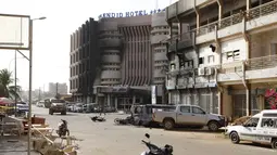 Suasana pasca serangan teror di hotel Splendid, Ouagadougou , Burkina Faso, (16/1).  Bangunan  hotel rusak dan beberpa kendaraan di dekat hotel hangus terbakar pasca serangan teror tersebut. (REUTERS / Joe Penney)