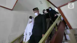 Pasangan Ririn  dan Zaenal saat melangsungkan pernikahan di KUA Kecamatan Matraman, Jakarta, Selasa (22/02/2022). Sejumlah pasangan sengaja melangsungkan pernikahan pada hari ini yang memiliki tanggal, bulan, dan tahun unik yakni 22-02-2022. (Liputan6.com/Herman Zakharia)