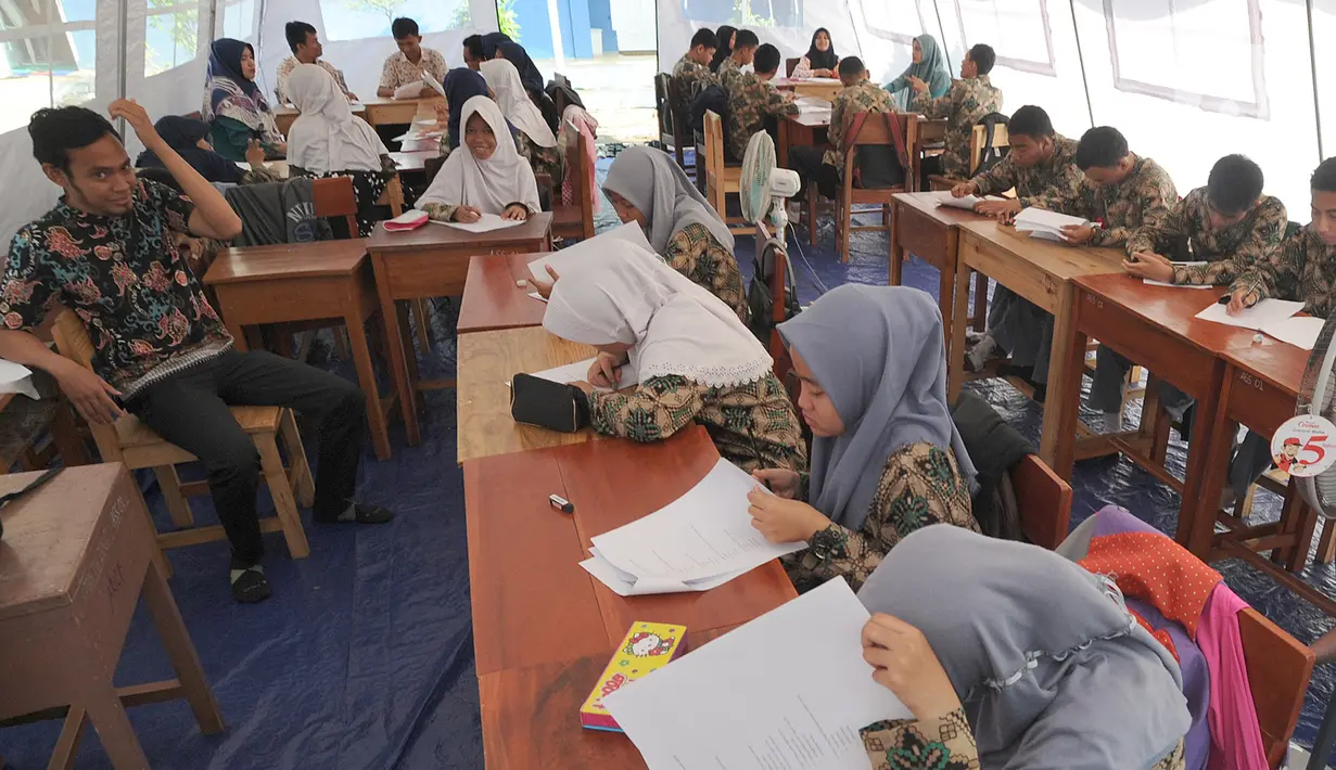 Murid SMP dan SMA Sekolah Khusus (SKh) Assalam 01 melaksanakan ujian di tenda darurat halaman SKh Assalam 02, Ciater, Serpong, Tangerang Selatan, Selasa (3/12/2019). Ujian diikuti murid penyandang tunarungu, tunawicara, dan tunagrahita tingkat SD hingga SMA. (merdeka.com/Arie Basuki)