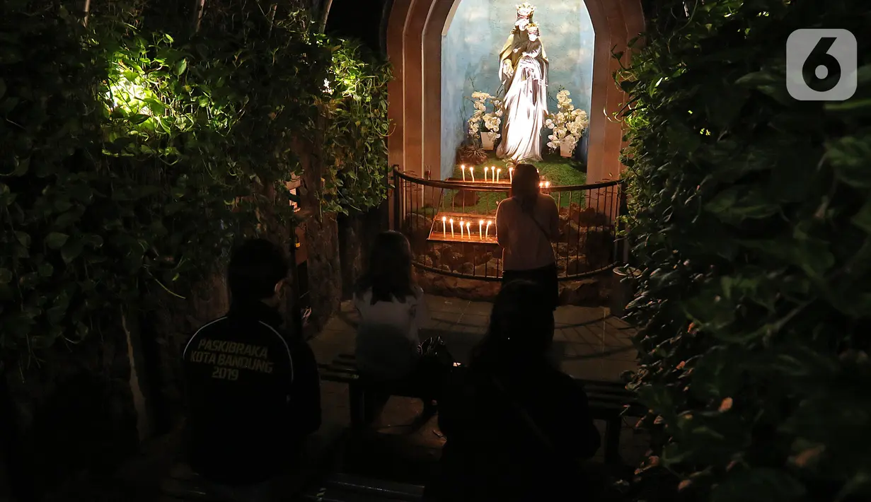 Jemaat umat kristiani melaksanakan Malam Misa Natal di Gereja Katedral Santo Petrus Bandung, Jawa Barat, Kamis (24/12/2020). Pohon Natal setinggi 16 meter yang selalu hadir menghiasi halaman gereja menjelang Hari Raya Natal ditiadakan. (Liputan6.com/Herman Zakharia)
