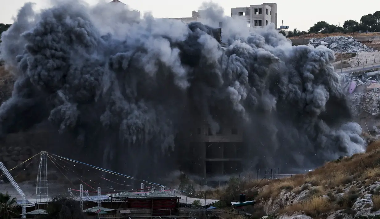 Sebuah bangunan Palestina yang sedang dibangun dihancurkan di desa Palestina Sur Baher di Yerusalem Timur (22/7/2019). Israel kembali menghancurkan sejumlah rumah Palestina yang dianggapnya dibangun secara ilegal di selatan Yerusalem. (AFP Photo/Ahmad Gharabli)
