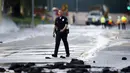 Seorang anggota kepolisian berjalan melintasi pecahan aspal akibat rusaknya pipa utama saluran air bawah tanah di sekitar Sunset Boulevard di bagian Westwood Los Angeles, (29/7/2014). (REUTERS/Danny Moloshok)