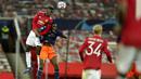 Pemain Istanbul Basaksehir, Demba Ba, duel udara dengan pemain Manchester United, Axel Tuanzebe, pada laga Liga Champions di Stadion Old Trafford, Rabu (25/11/2020). Setan Merah menang dengan skor 4-1. (AP/Dave Thompson)