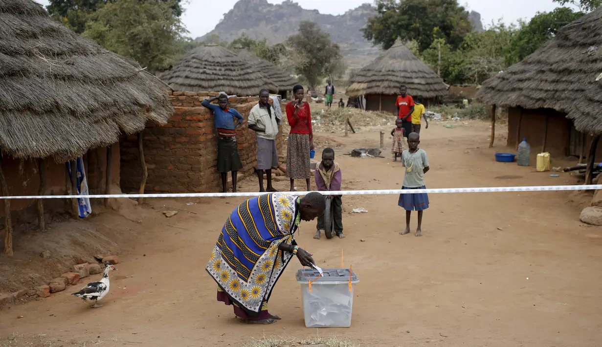 Warga suku Karamojong memasukkan kertas suara kedalam kotak di TPS desa dekat kota Kaabong, Uganda, (18/2). Uganda memiliki berbagai macam suku yang warganya masih tertinggal dengan kota - kota besar. (REUTERS / Goran Tomasevic)