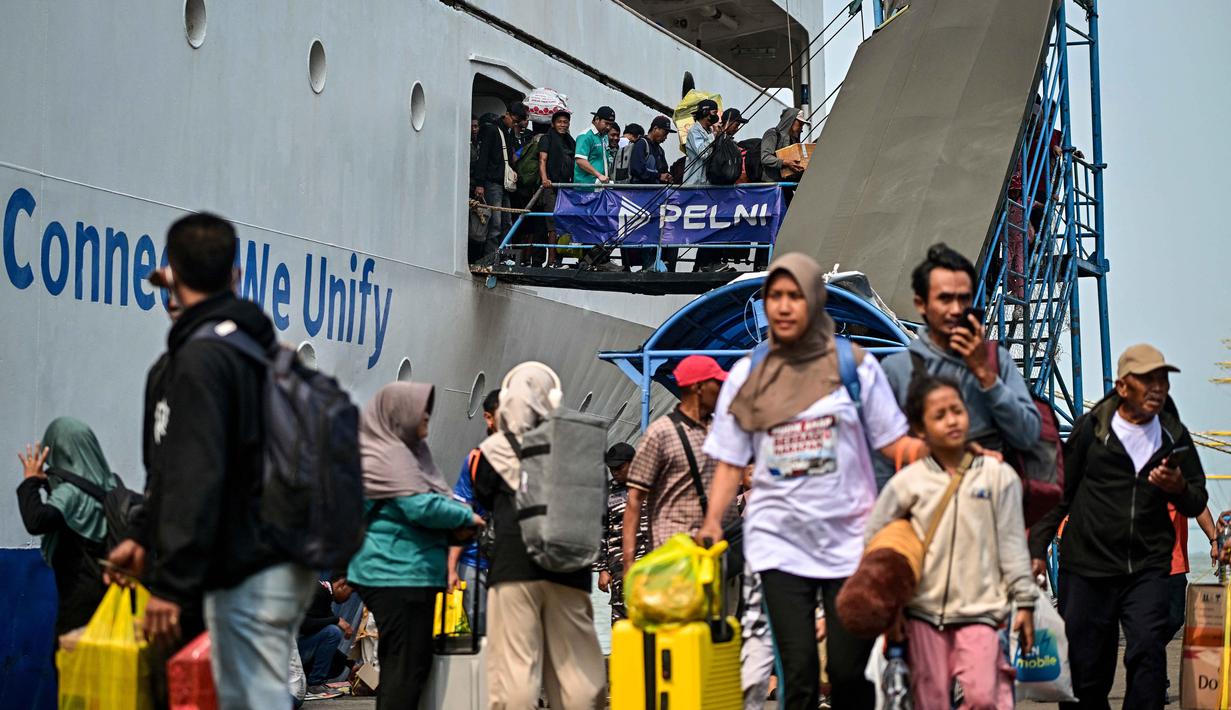 Para penumpang berjalan keluar untuk turun dari kapal di pelabuhan Perak, Surabaya, Jawa Timur pada Minggu 15 Maret 2026. Arus mudik di Pelabuhan Tanjung Perak, Surabaya, Jawa Timur, memasuki periode dengan jumlah penumpang yang signifikan. (JUNI KRISWANTO/AFP)