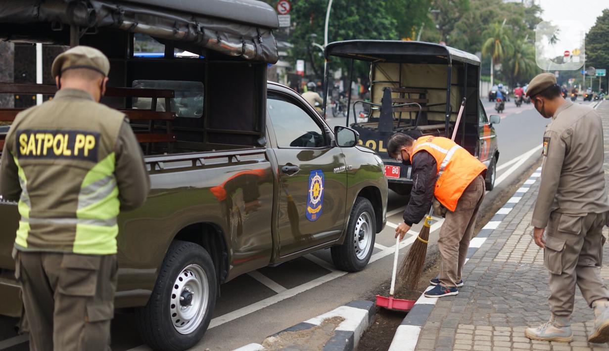 Petugas gabungan menghukum warga saat Operasi Yustisi Protokol Covid-19 di kawasan Tugu Tani, Jakarta, Senin (14/9/2020). Operasi tersebut digelar sebagai langkah untuk menekan penyebaran Covid-19 di masa PSBB Jakarta. (Liputa6.com/Immanuel Antonius)