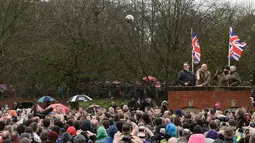 Sebuah bola dilempar ke udara menandai dimulainya perayaan The Royal Shrovetide Football Match, Inggris, Selasa (28/2). Tradisi ini telah ada sejak abad ke-12. (AFP Photo/ Oli SCARFF)