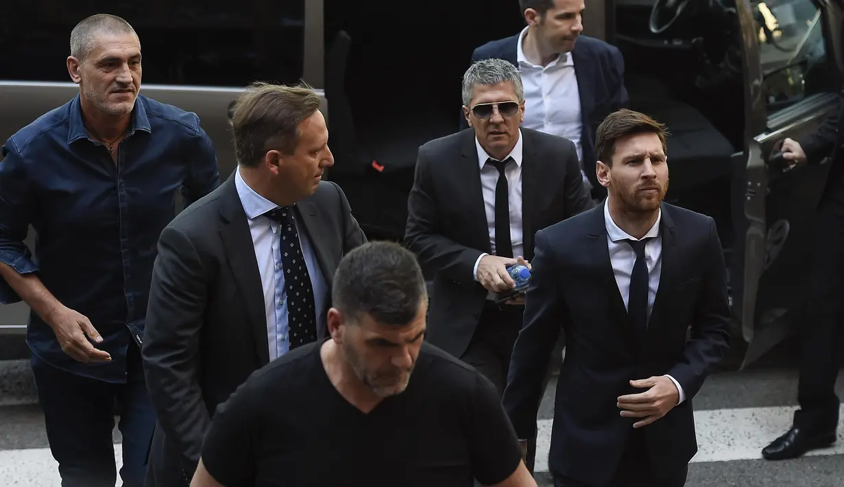 Bintang Barcelona, Lionel Messi (kanan) dan ayahnya, Jorge Horacio Messi mendapat pengawalan ketat saat menuju pengadilan di Kantor Pengadilan Barcelona, (2/6/2016). (AFP/Josep Lago)