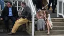 Dua penggemar balap kuda atau racegoers saat menghadiri pembukaan Festival Grand National di arena Aintree, Liverpool, Inggris (7/4). Kehadiran racegoers memberikan nuansa tersendiri di kompetisi pacuan kuda terbesar tersebut. (AFP Photo / Oli Scarff)
