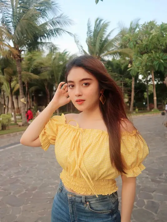 Perpaduan crop top sabrina dengan celana jeans memang adalah penampilan yang tepat untuk gaya casual. Busana berwarna kuning, membuat pemain film Mata Batin 2 ini semakin trendi. (Liputan6.com/IG/@nblh.ayu)