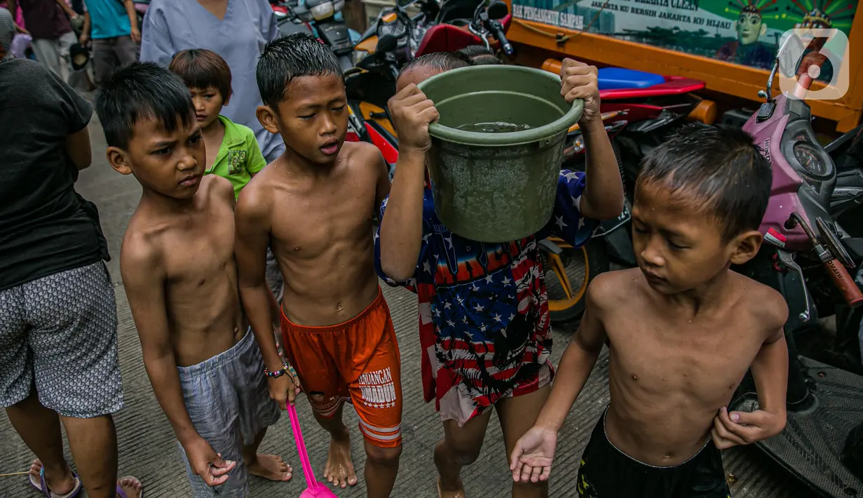 Anak-anak korban banjir bermain di luar Gedung Sekolah SDN 01/02 Kampung Melayu, Jakarta, Selasa (9/2/2021). Gedung sekolah tersebut menjadi salah satu posko pengungsian bagi Sebagian korban banjir di kawasan Kebon Pala. (Liputan6.com/Faizal Fanani)
