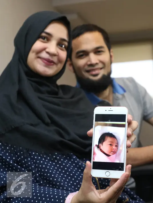 Shireen Sungkar menunjukkan foto anak kedua mereka di RS Pondok Indah, Jakarta, Rabu (27/7). Pemberian nama Medina pada anak kedua mereka berarti kota Madinah yang merupakan kota impian Shireen dan Wisnu. (Liputan6.com/Herman Zakharia) 