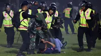 Petugas keamanan menahan seorang suporter saat kerusuhan pada pertandingan sepak bola antara Arema Vs Persebaya di Stadion Kanjuruhan, Malang, Jawa Timur, 1 Oktober 2022. "Dalam kejadian itu, telah meninggal 127 orang, dua di antaranya adalah anggota Polri," kata Kapolda Jawa Timur Irjen Pol Nico Afinta. (AP Photo/Yudha Prabowo)