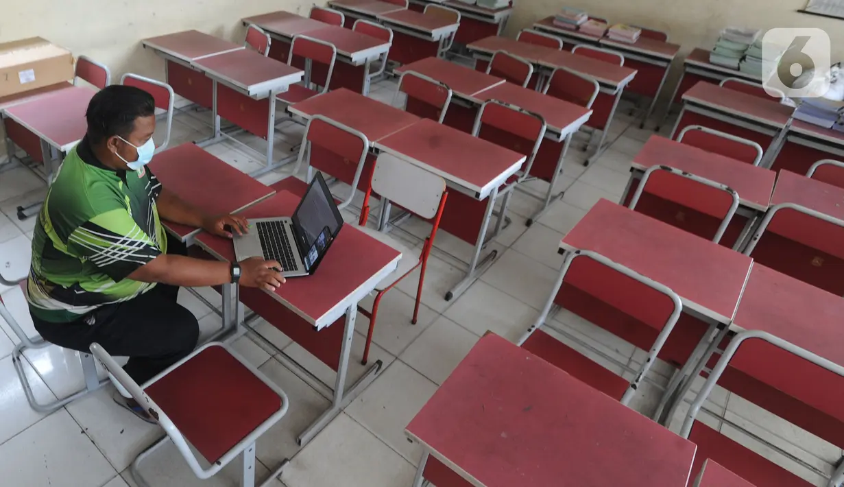 Guru mengajar mata pelajaran olah raga secara darling pada sebuah kelas kosong di SDN Pondok Cabe Udik 01, Pamulang, Tangerang Selatan, Jumat (8/1/2020). Berdasarkan SK Gubernur Banten terkait pembatalan kegiatan belajar tatap muka dikarenakan tingkat penularan covid-19 masih tinggi. (merdeka.com/Ar