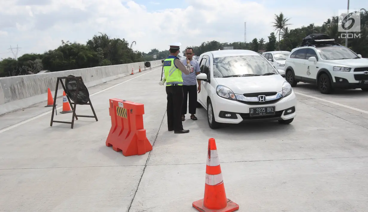 Petugas berbincang dengan pemudik di ruas Tol Salatiga-Kartasura, Barukan, Kabupaten Semarang, Jateng, Selasa (12/6). Pengalihan dilakukan agar kendaraan untuk tidak memasuki ruas Tol Salatiga-Kartasura. (Liputan6.com/Arya Manggala)