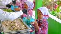 Anak-anak SDN Kosambi, Kampung Kosambi 2, Desa Karang Suraga, Kecamatan Cinangka, Kabupaten Serang, mengantre untuk mendapatkan makan siang bergizi di sekolah. (dok. Archipelago)