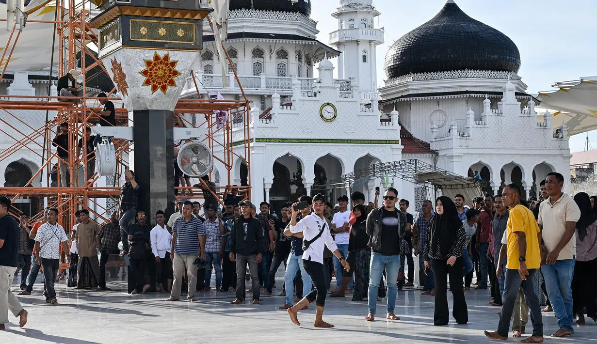 Para pengunjuk rasa yang marah meneriaki tentara saat mereka menurunkan bendera Gerakan Aceh Merdeka (GAM) yang dikibarkan berdampingan dengan bendera nasional Indonesia dalam sebuah unjuk rasa di Masjid Raya Baiturrahman, Banda Aceh, Sabtu, 15 September 2026. (AFP/ Chaideer Mahyuddin)