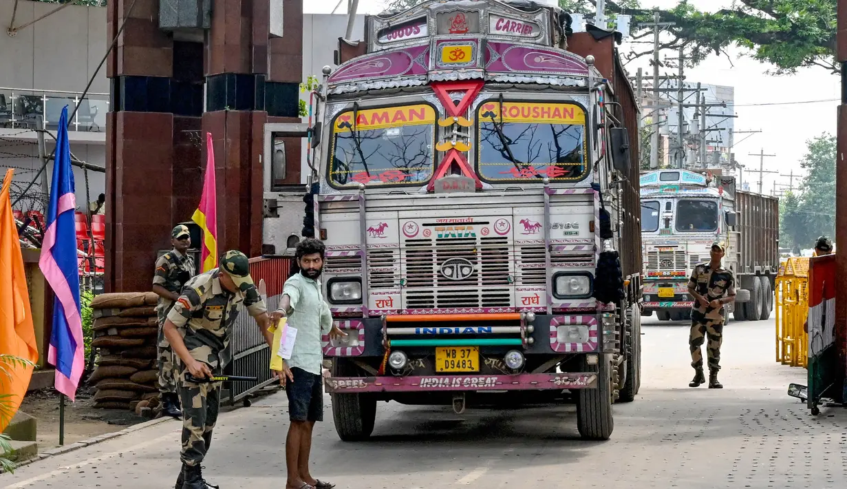 Personel Pasukan Keamanan Perbatasan (BSF) memeriksa seorang pengemudi truk ketika ia kembali ke India setelah mengantarkan pasokan ke Bangladesh, di perbatasan India-Bangladesh, Petrapole, sekitar 100 km sebelah timur laut Kolkata pada tanggal 6 Agustus 2024. (Dibyangshu SARKAR/AFP)