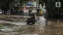 Warga menuntun sepedanya saat melewati banjir di kawasan Tendean Jakarta, Sabtu (20/2/2021). Curah hujan yang tinggi menyebabkan banjir setinggi orang dewasa di kawasan Tendean. (Liputan6.com/Johan Tallo)