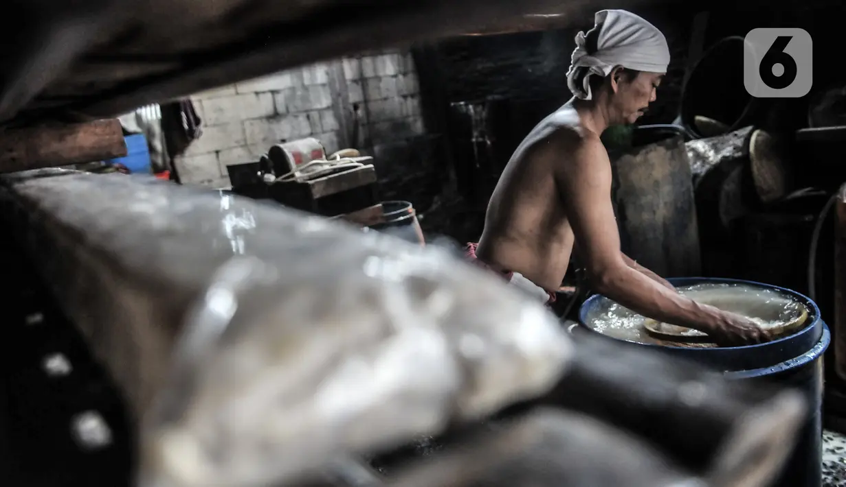 Pekerja mengolah kedelai untuk dijadikan tempe di industri rumahan kawasan Sunter, Jakarta, Senin (4/1/2021). Perajin tempe setempat berupaya mengurangi kerugian akibat melonjaknya harga kedelai impor dengan memperkecil ukuran tempe dan menaikan harga jual. (merdeka.com/Iqbal S. Nugroho)