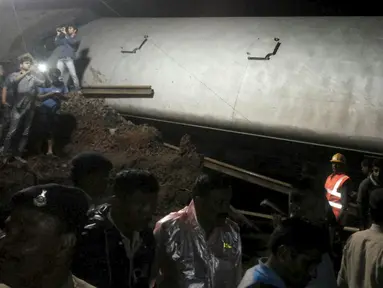 Petugas penyelamat berusaha mengevakuasi kereta penumpang yang keluar dari rel di Negara Bagian Madhya Pradesh, India, Selasa (4/8/2015). Beberapa gerbong dari kedua kereta penumpang tersebut jatuh ke sungai yang meluap. (REUTERS/ANI/Handout via Reuters)