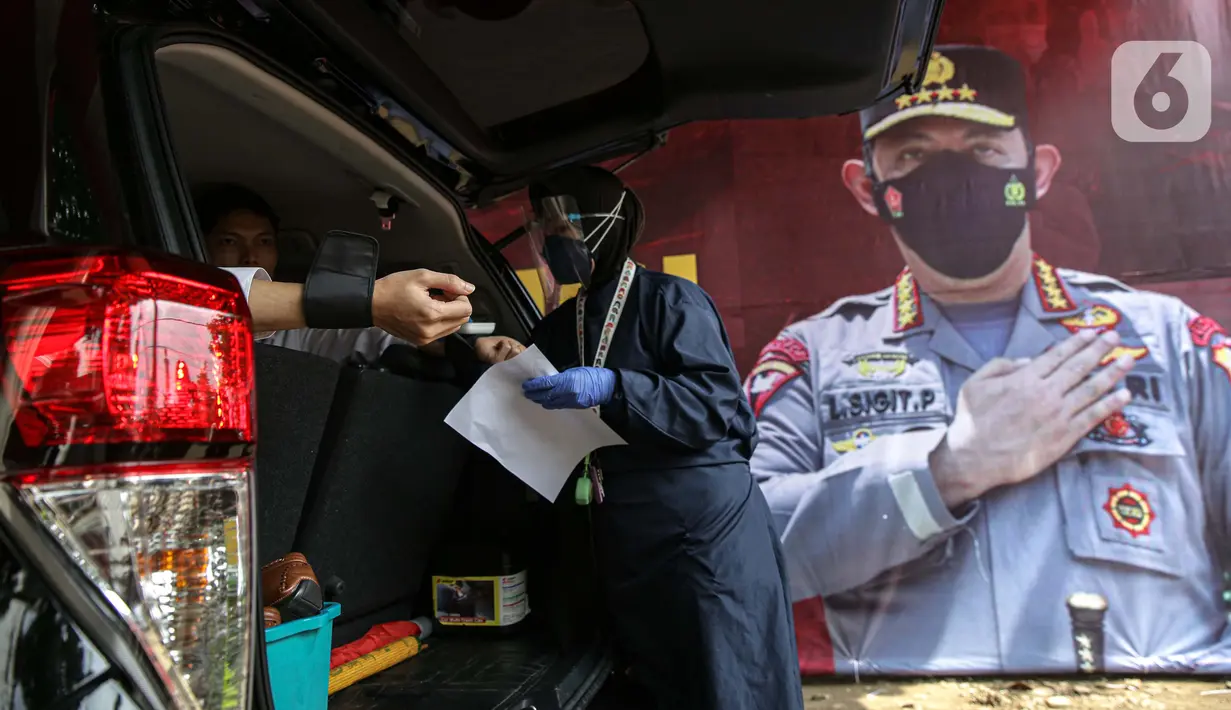 Petugas mendata kondisi warga saat pelaksanaan vaksinasi COVID-19 secara drive-thru di Mapolres Jakarta Selatan, Selasa (29/6/2021). Layanan ini dilakukan untuk mempercepat vaksinasi COVID-19 kepada warga. (Liputan6.com/Faizal Fanani)