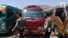 Petugas polisi memeriksa mobil travel gelap yang disita di halaman Polres Metro Kabupaten Bekasi, Jawa Barat, Senin (10/5/2021). Satlantas Polres Metro Bekasi mengamankan 32 travel gelap yang masih beroperasi saat larangan mudik dari tanggal 6-17 Mei 2021. (Liputan6.com/Herman Zakharia)