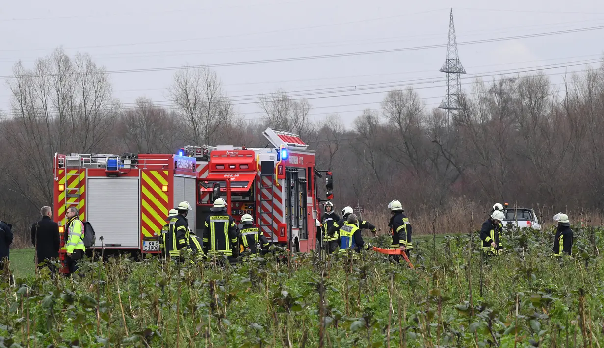 Pemadam kebakaran memeriksa lokasi kecelakaan udara antara pesawat kecil dengan helikopter di Philippsburg, Jerman, Selasa (23/1). Kecelakaan terjadi sekitar 5 km dari Kota Philippsburg yang memiliki sebuah reaktor nuklir. (Rene Priebe/dpa via AP)
