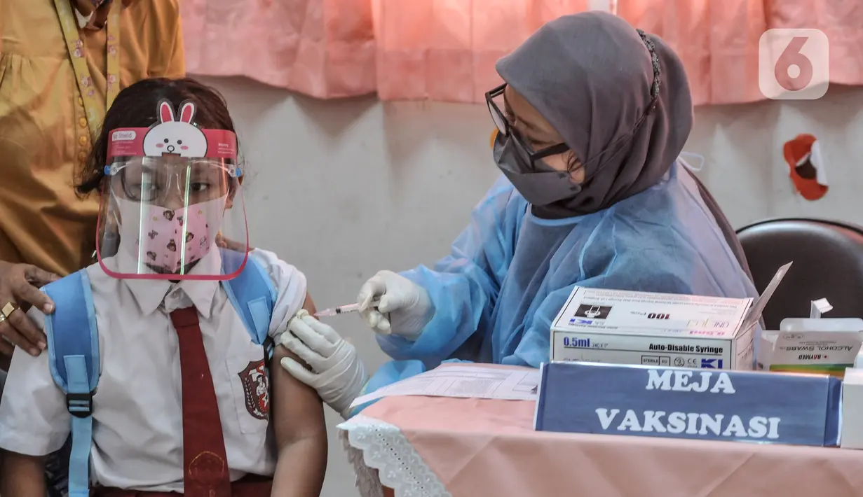 Seorang murid menjalani vaksinasi COVID-19 di SDN Cempaka Putih Timur 03 Pagi, Jakarta, Selasa (14/12/2021). Vaksinasi untuk anak usia 6-11 tahun dilakukan secara bertahap dengan target 26,7 juta anak. (merdeka.com/Iqbal S. Nugroho)
