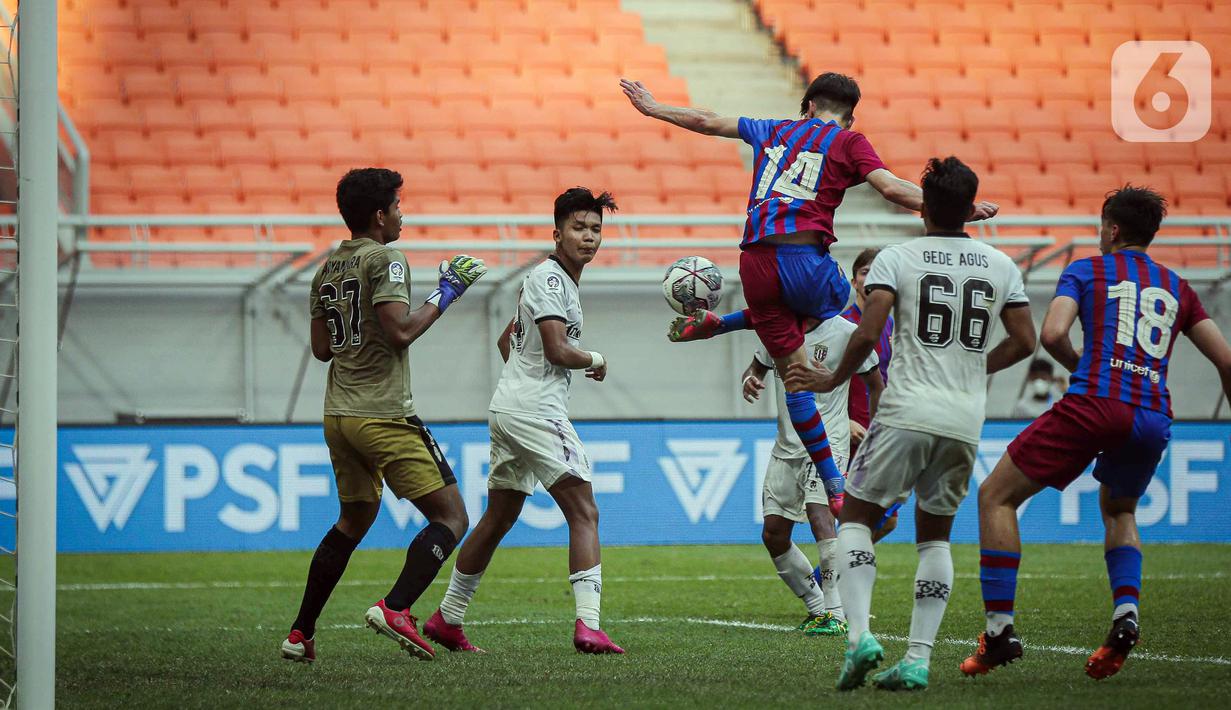 Pemain Barcelona U-18 Jan Molina Vilaseca (tengah) menendang bola ke gawang Bali United U-18 pada pertandingan International Youth Championship (IYC) 2021 di Jakarta International Stadium (JIS), Jakarta, Minggu (17/4/2022). Barcelona U-18 menang 4-0. (Liputan6.com/Faizal Fanani)