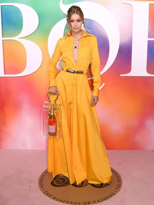 Model Gigi Hadid berpose di karpet merah gala Business of Fashion 500 (BOF 500) selama New York Fashion Week di Brooklyn City, 9 September 2018. Uniknya, Gigi percaya diri membawa tas kotak kaca berisi botol anggur merah. (NICHOLAS HUNT/GETTY IMAGES/AFP)