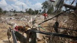 Banjir bandang yang menerjang Kabupaten Aceh Tamiang pada Rabu 26 November 2025, menimbulkan kerusakan parah. Tampak dalam foto, seorang korban membawa tas berisi barang-barang yang diselamatkan di daerah yang terdampak banjir bandang di Aceh Tamiang, Jumat 5 Desember 2025. (AP Photo/Binsar Bakkara)