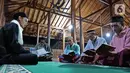 Sejumlah warga Baduy muslim melaksanakan tadarus di Kampung Landeuh, Lebak, Banten, Selasa (27/4/2021). Selama Ramadhan, warga Baduy muslim melaksanakan sholat tarawih sampai tadarus dan makan bersama. (Liputan6.com/Herman Zakharia)