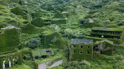 Kondisi sejumlah rumah yang ditutupi tumbuhan di Houtouwan di pulau Shengshan, provinsi Zhejiang, China (31/5). Rumah-rumah yang ditutupi dengan tumbuhan ini seolah-olah seperti disegel dalam lapisan hijau yang lebat. (AFP/Johannes Eisele)