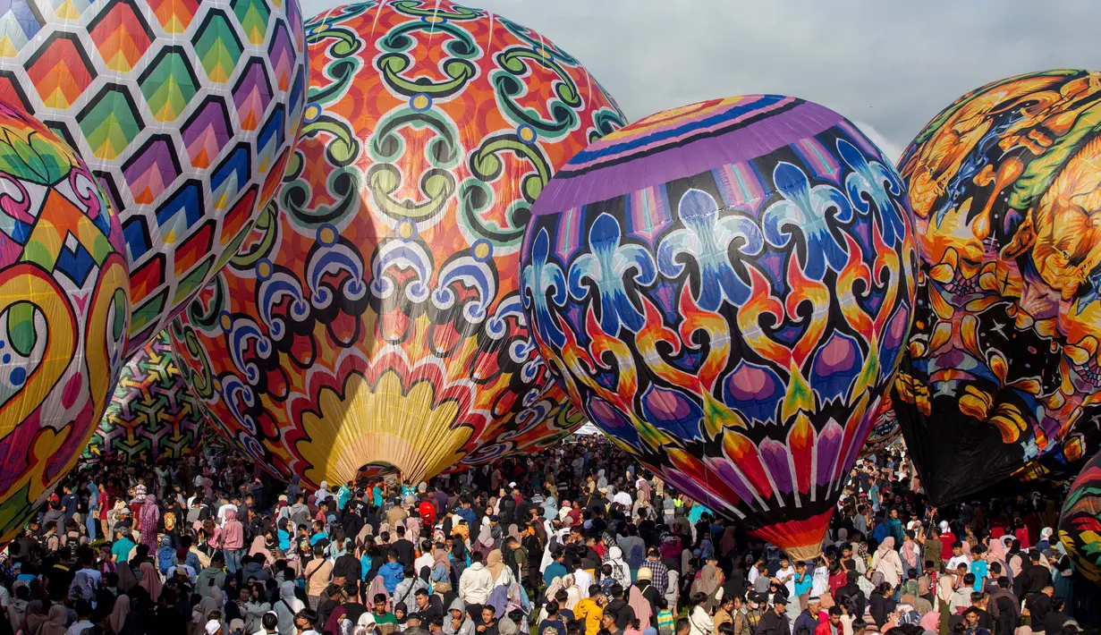 Para peserta bersiap menerbangkan balon udara dalam festival balon udara tradisional di Wonosobo, Jawa Tengah pada 11 April 2024. (DEVI RAHMAN/AFP)