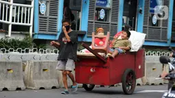 Pemulung melintas di Jalan Matraman Raya, Jakarta, Kamis (30/4/2020). Setiap Ramadan tiba, kemunculan pemulung yang membawa gerobak marak terjadi. Saat ini, kemunculan mereka menjadi masalah tersendiri di tengah upaya memutus mata rantai penyebaran Covid-19. (Liputan6.com/Helmi Fithriansyah)